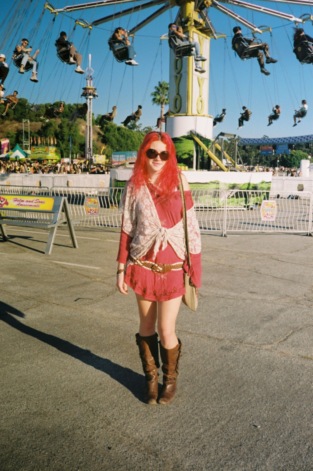 a girl with red hair in front of the swings at tyler the creator's camp flog gnaw