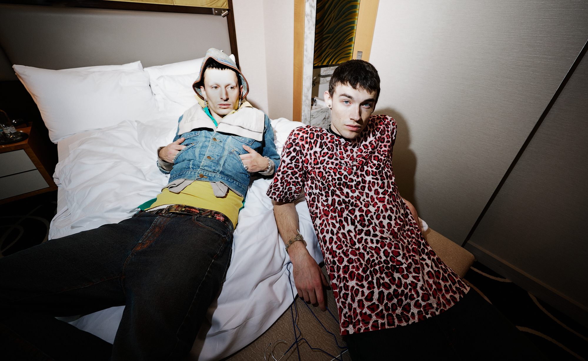 nation lying across a hotel bed photographed by julien tell