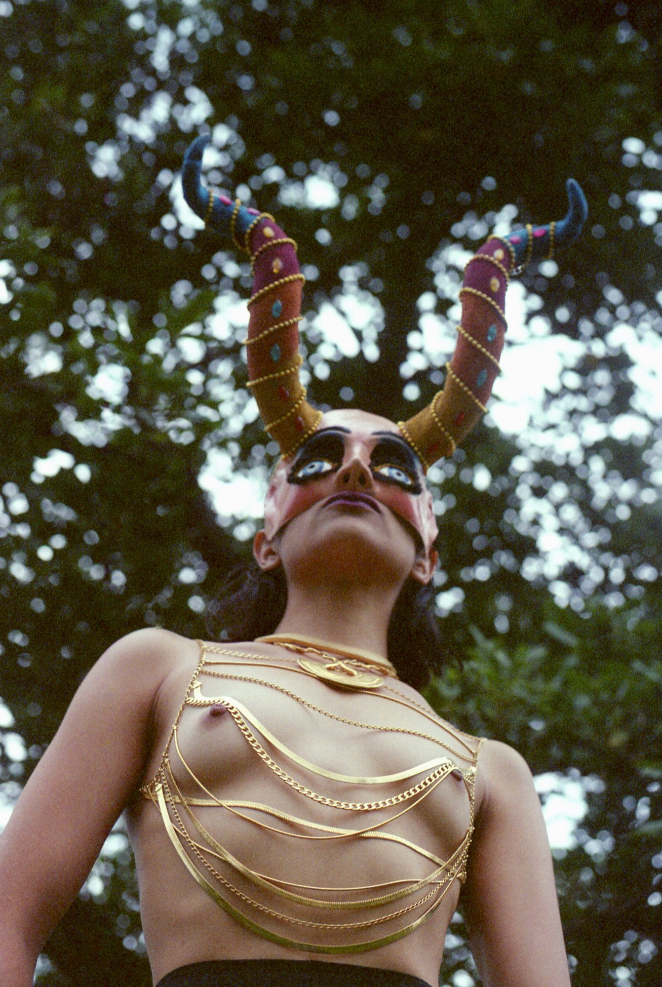 a young woman in a hold chain corset, and horned mask