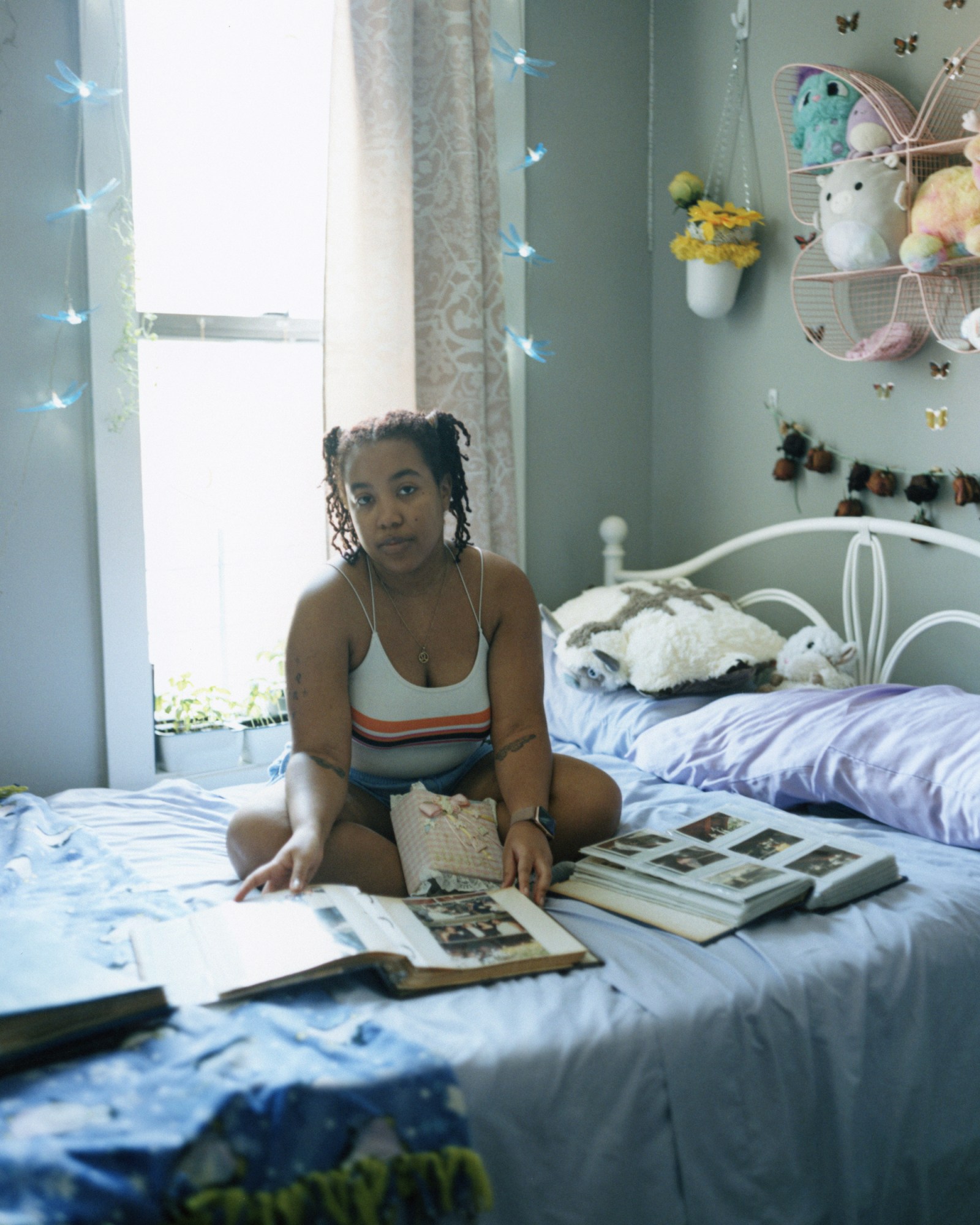 nande walters sitting on a blue bed with photo albums