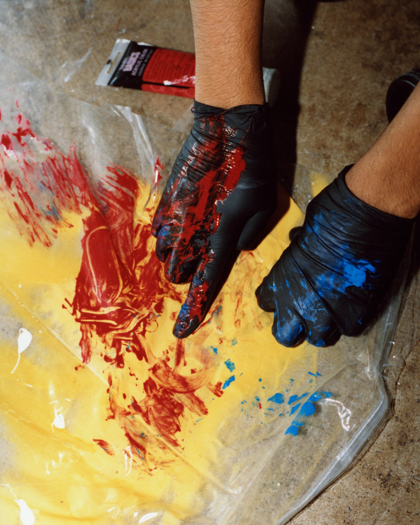 black gloves with red and blue paint