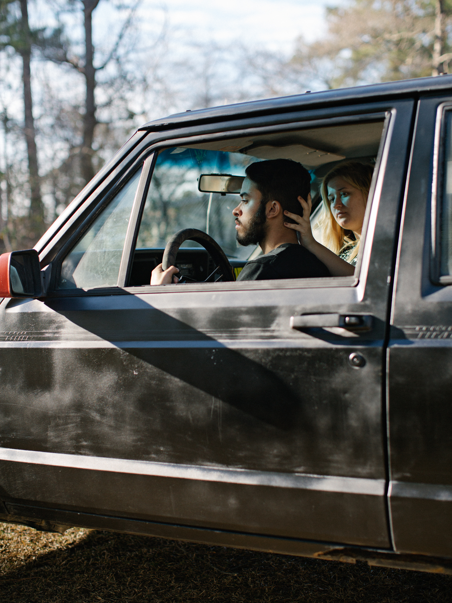 Manny and Courtney looking out the window of a black jeep