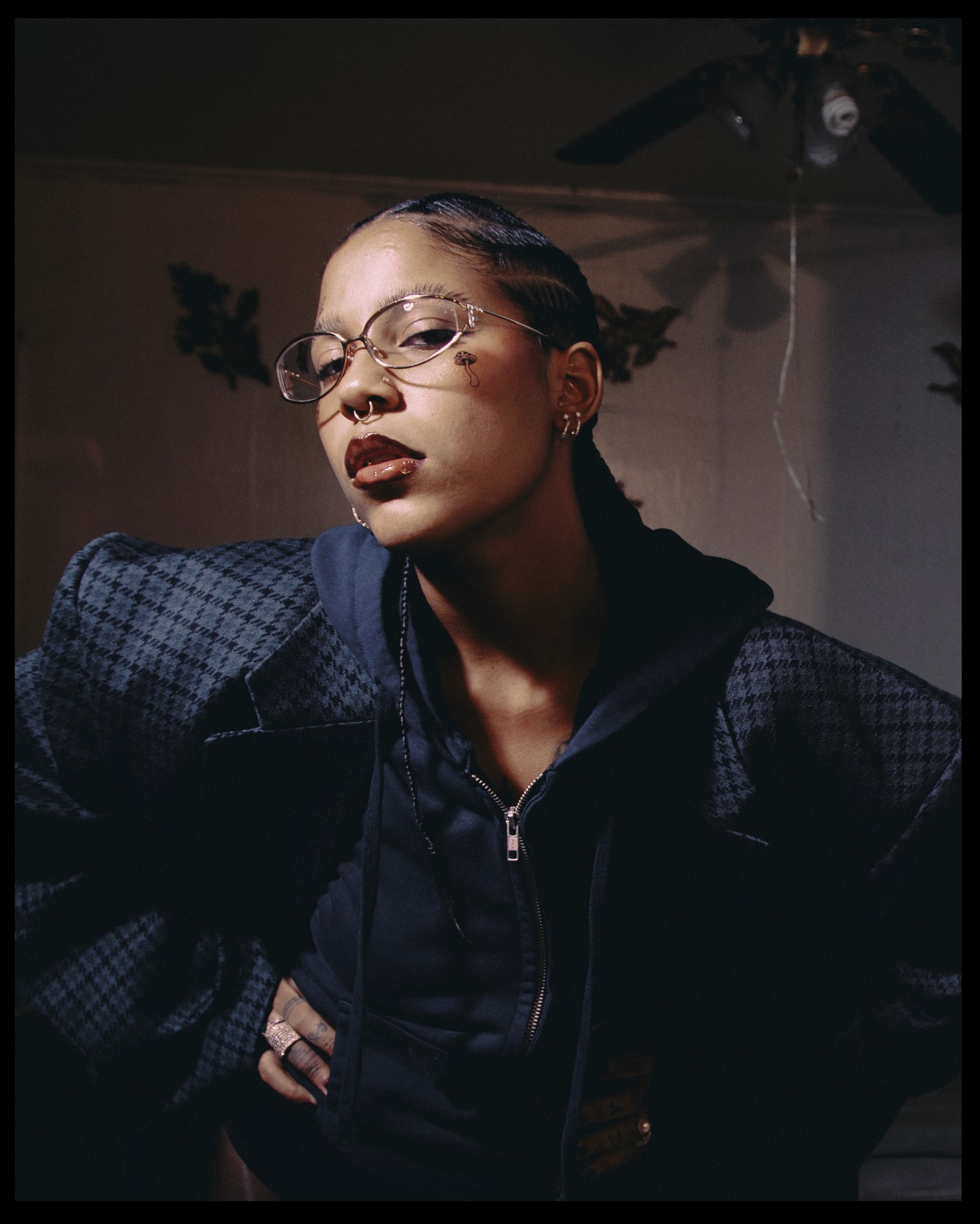 dominican rapper tokischa in glasses and tattoos looking down at the camera