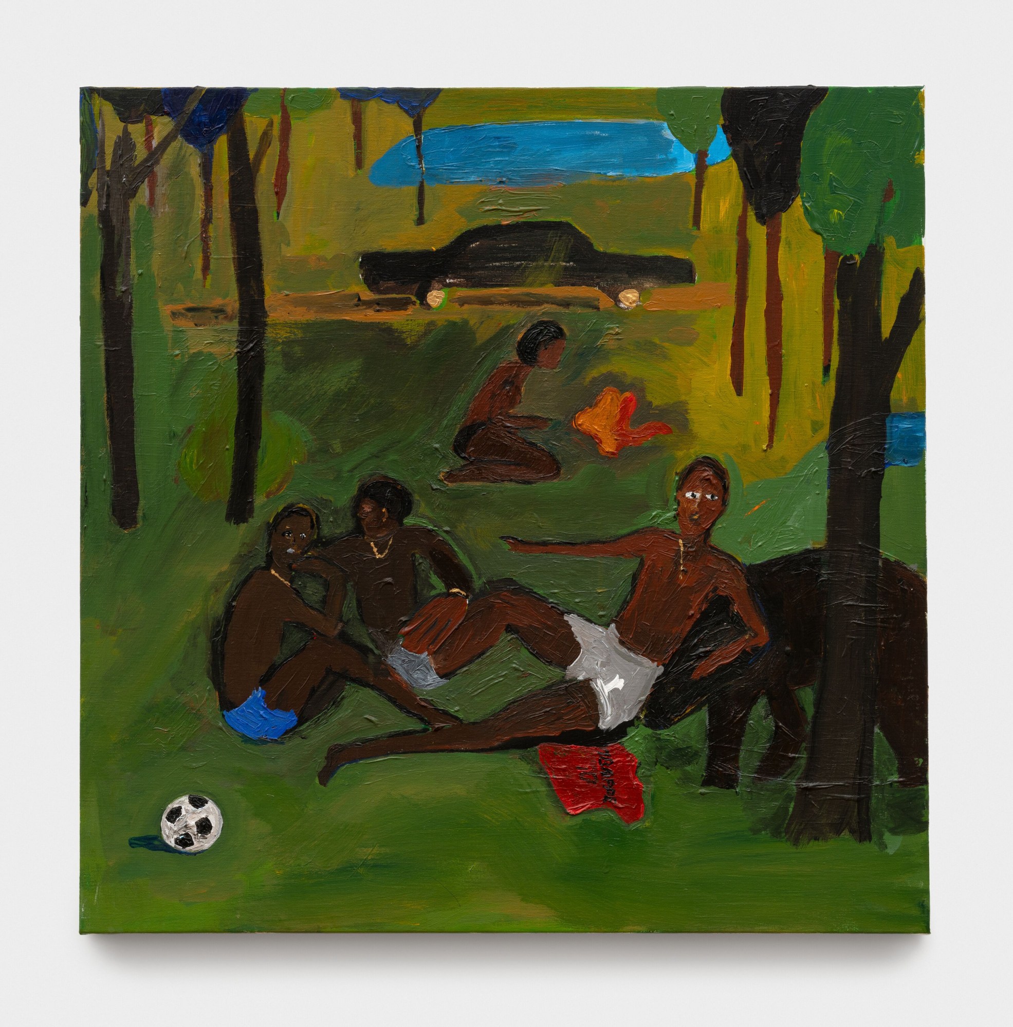 three men sitting on grass next to a soccer ball