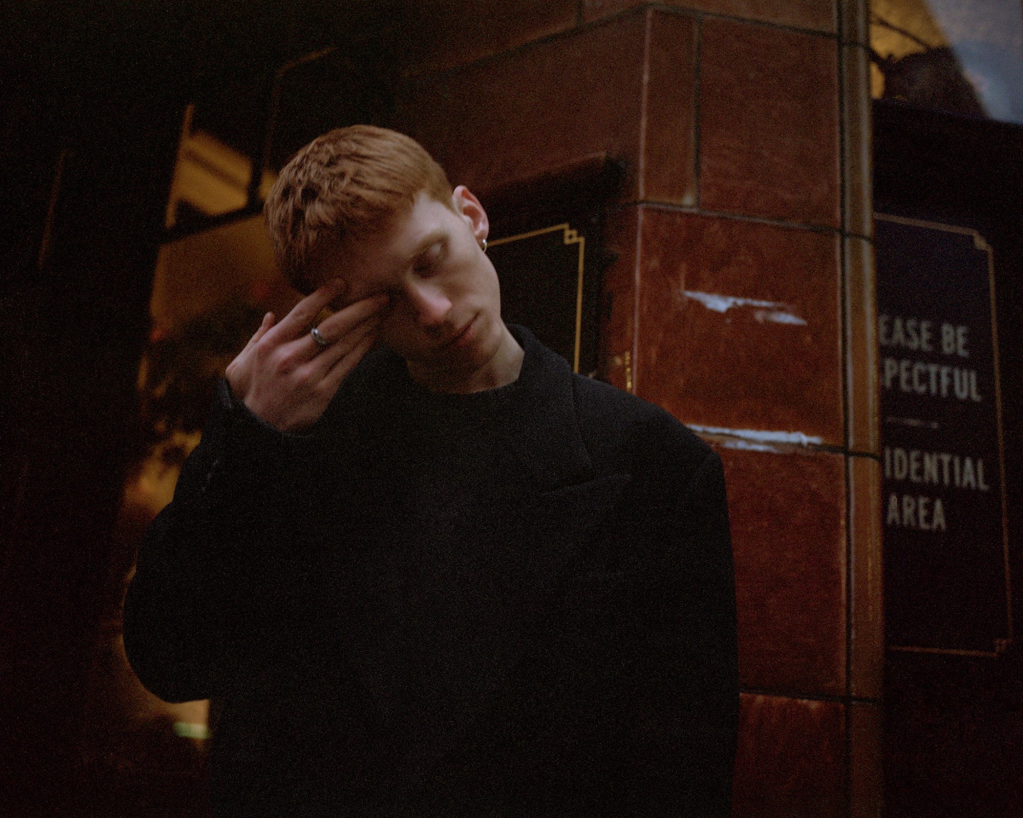 luther ford actor standing outside a pub covering his eye