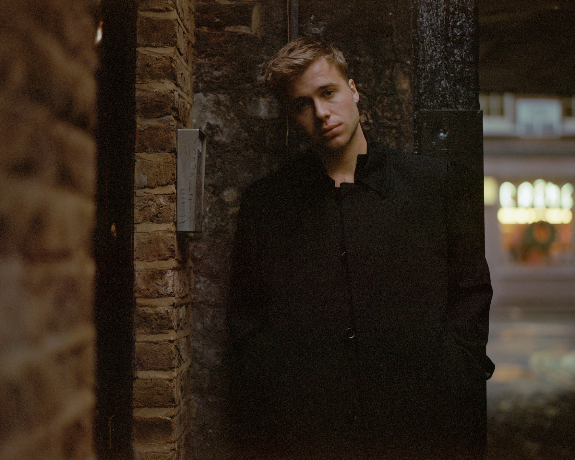 ed mcvey actor standing in an alleyway wearing a black coat