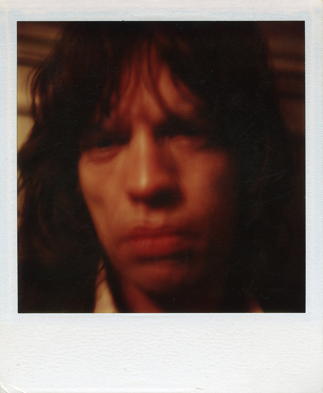 a blurry close up of mick jagger taken on a polaroid camera