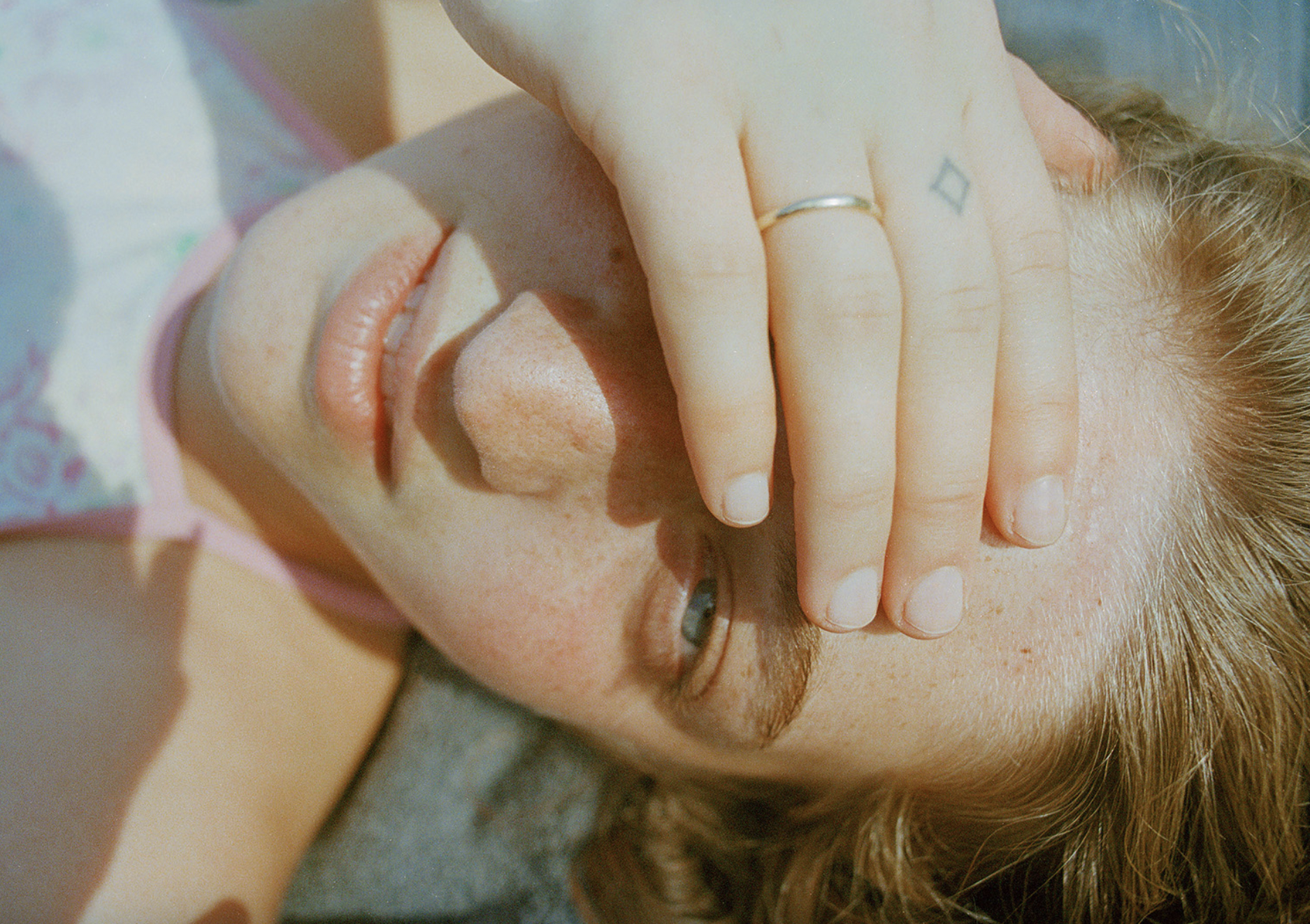 Photograph by J Houston of a girl with her hand over one eye from 'Tuck and Roll'