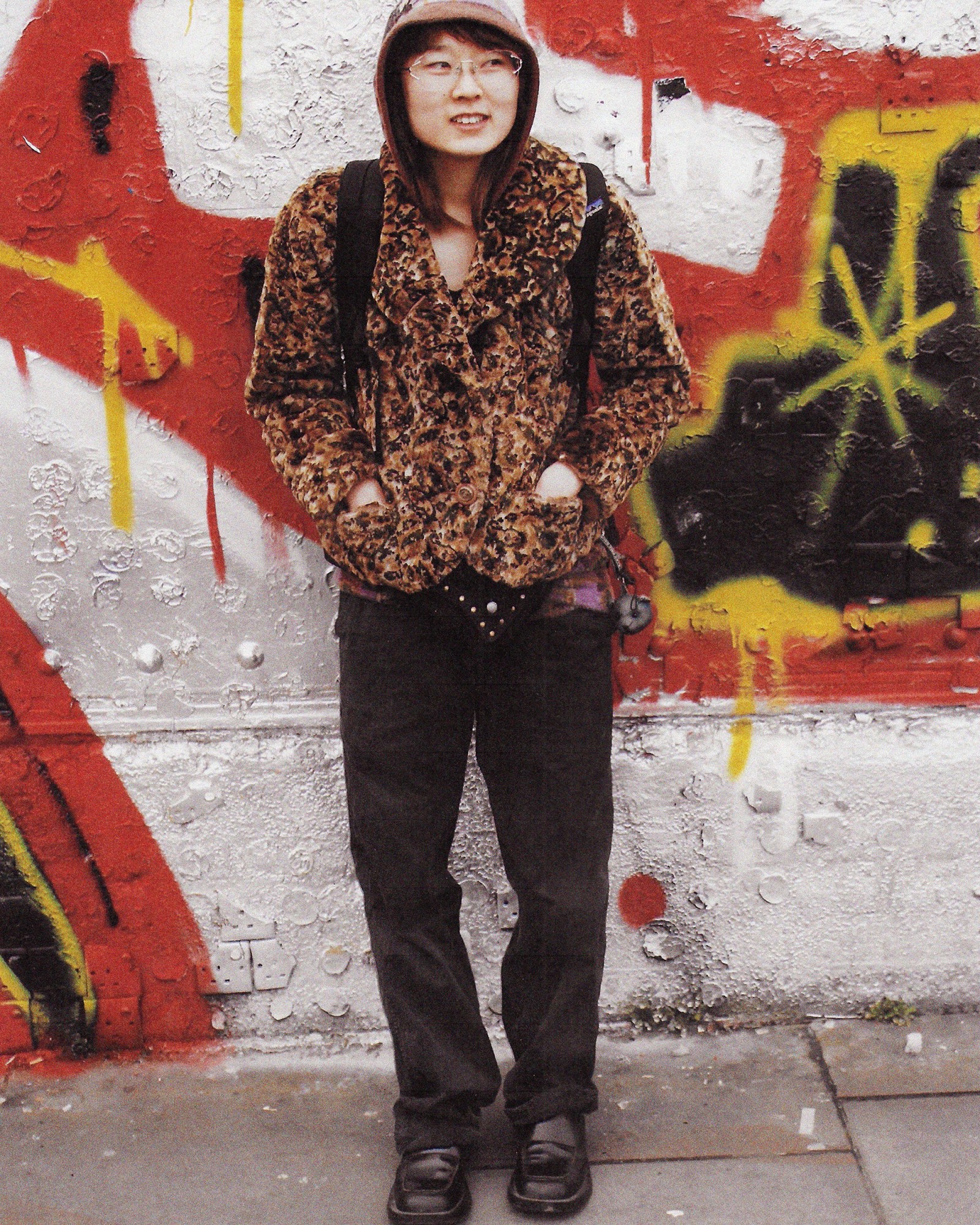 A full length photograph of a person wearing a fur jacket and jeans in London.