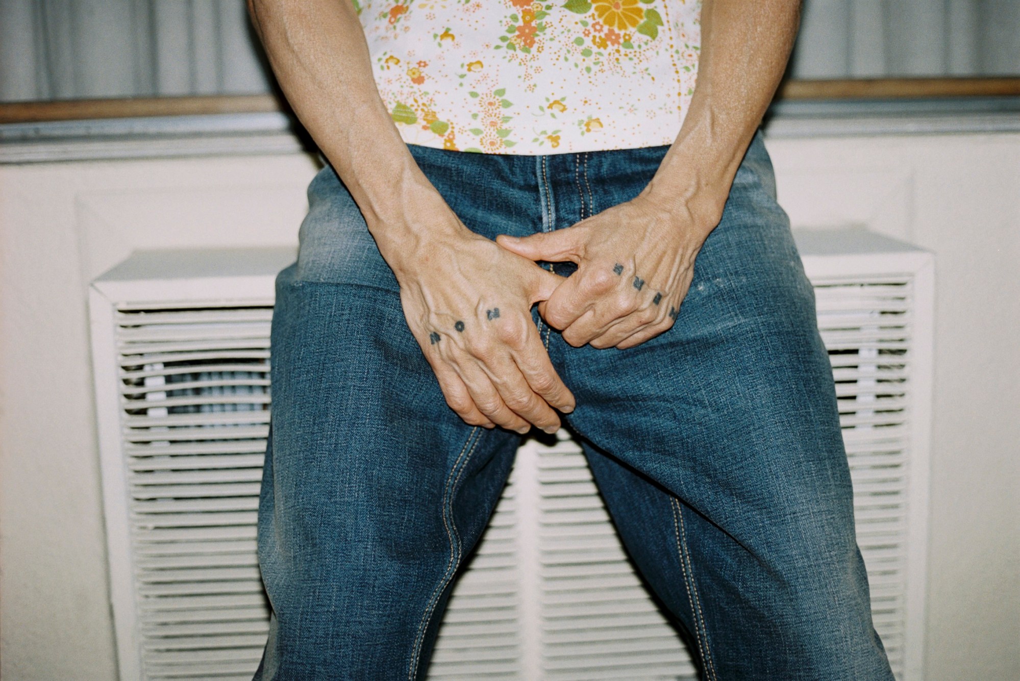 Gregg Araki by Kevin Amato for i-D magazine issue 375, fall/winter 2025. He'd holding his crotch and showing his hand tattoos.