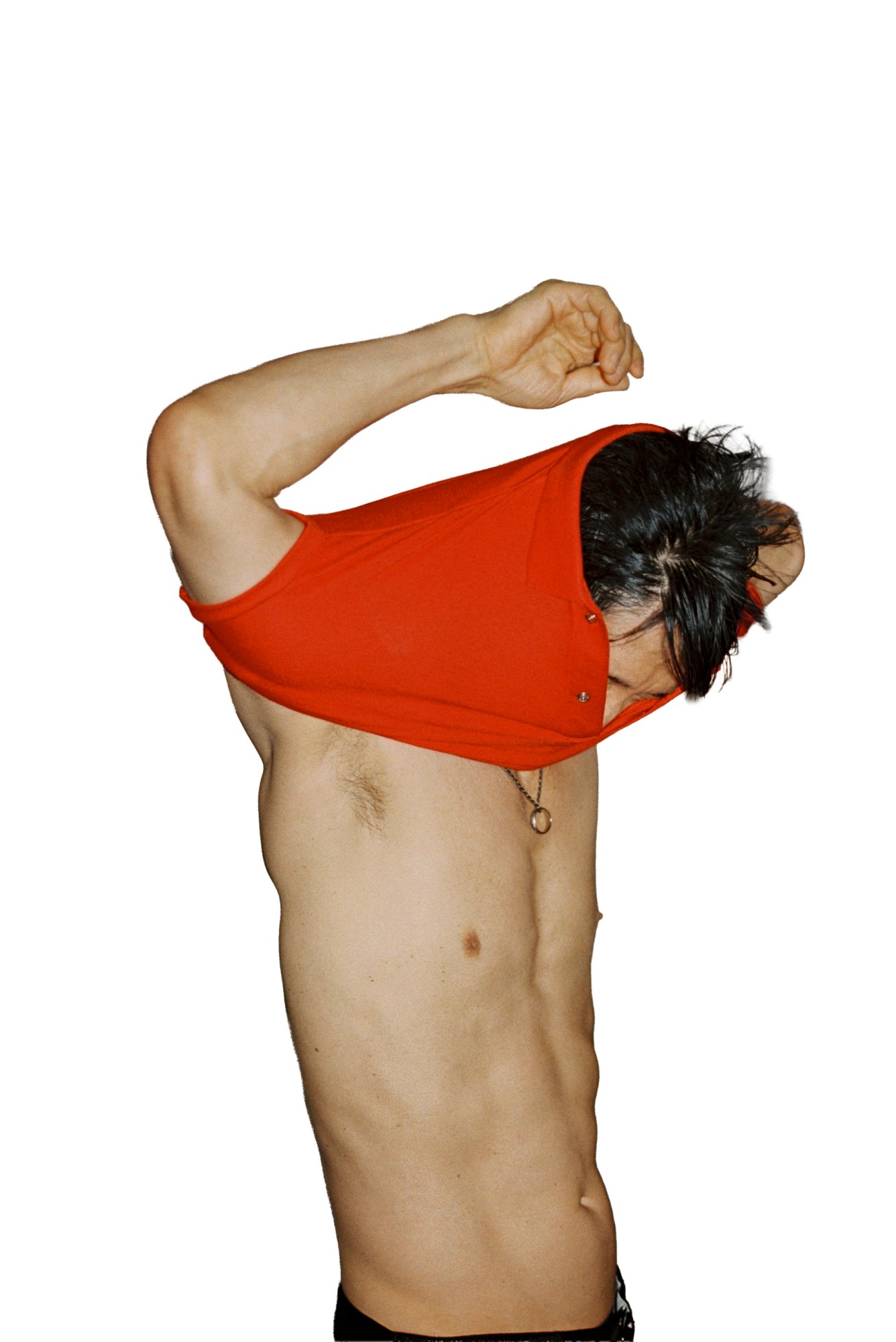 Gregg Araki by Kevin Amato for i-D magazine issue 375, fall/winter 2025. He's stretching a red polo shirt over his head